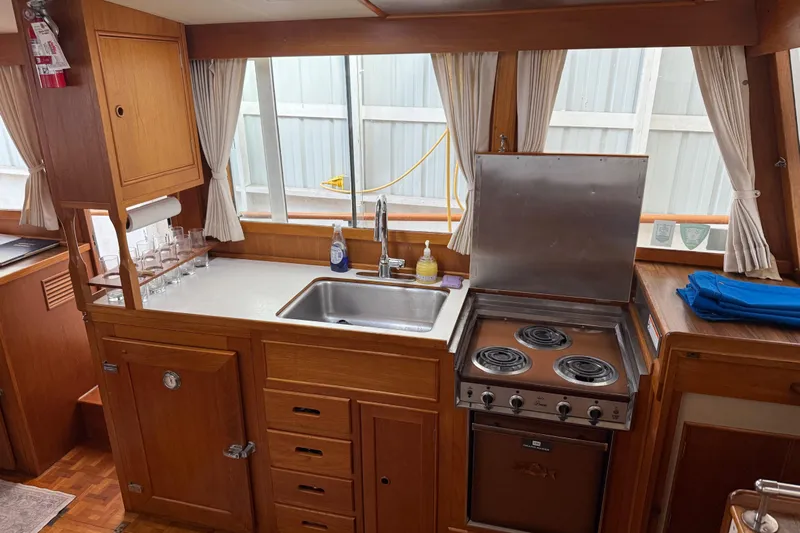  Yacht Photos Pics 1981 Grand Banks 42 Classic yacht kitchen with stove, sink, and wooden cabinetry.