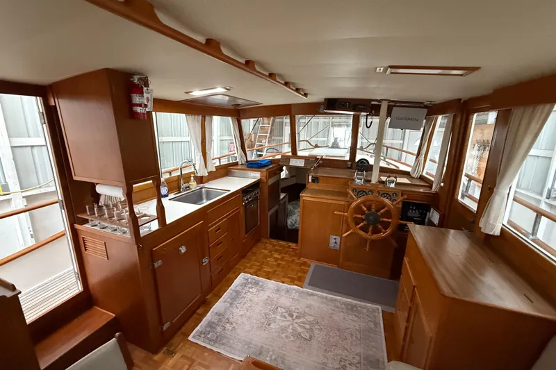  Yacht Photos Pics 1981 Grand Banks 42 Classic yacht interior with wooden helm, kitchen, and navigation equipment.