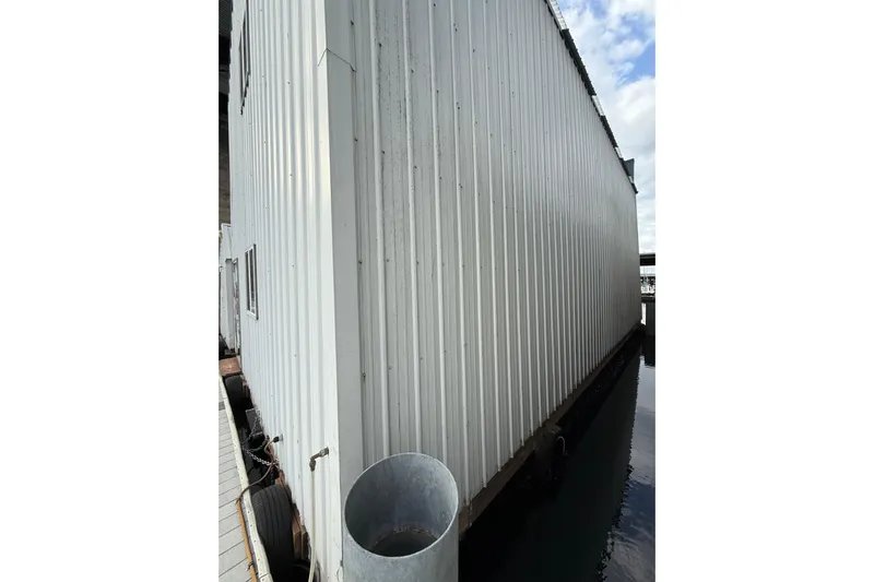  Yacht Photos Pics Side view of a docked Grand Banks 42 Classic boat, 1981 model, beside a metal structure.