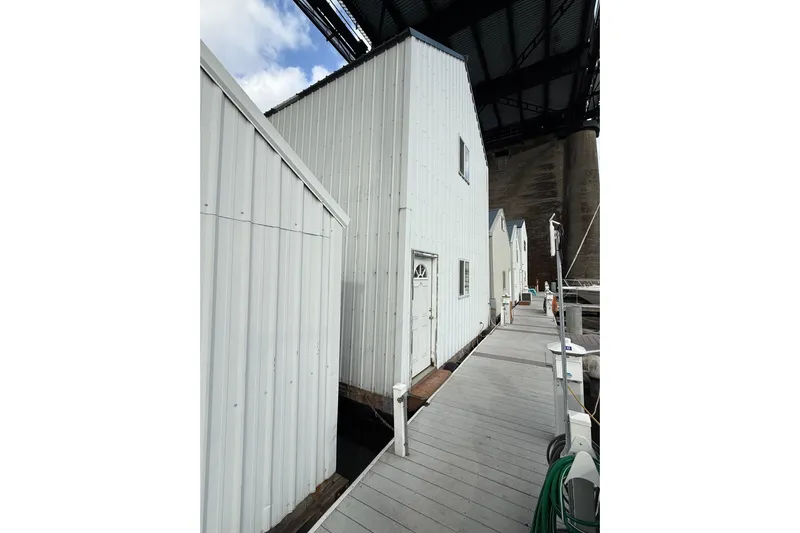  Yacht Photos Pics Marina dock with white buildings under a bridge, featuring a Grand Banks 42 Classic, 1981.