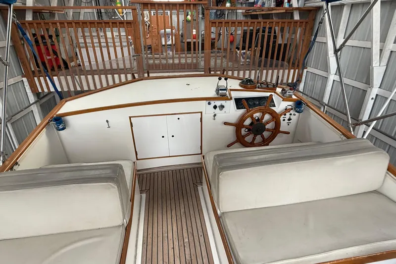  Yacht Photos Pics 1981 Grand Banks 42 Classic boat helm with wooden wheel and cushioned seating.