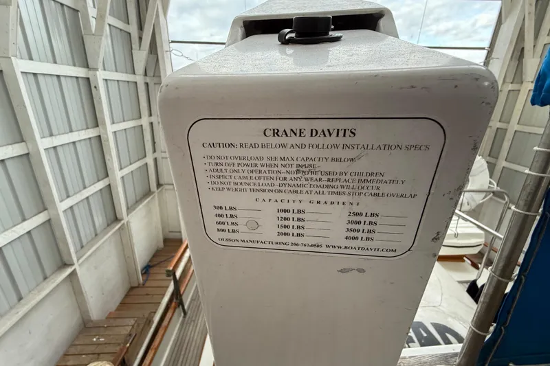  Yacht Photos Pics Crane davits on 1981 Grand Banks 42 Classic, displaying capacity and safety instructions.