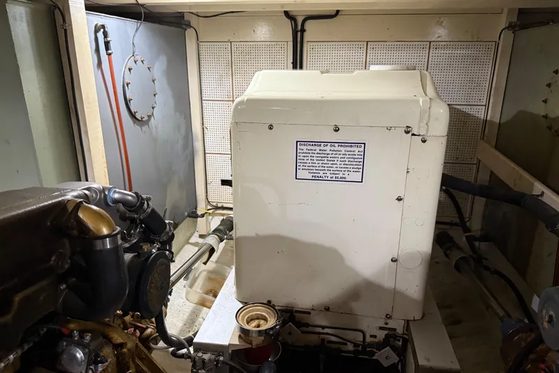  Yacht Photos Pics Engine room of a 1981 Grand Banks 42 Classic yacht, featuring machinery and warning sign.