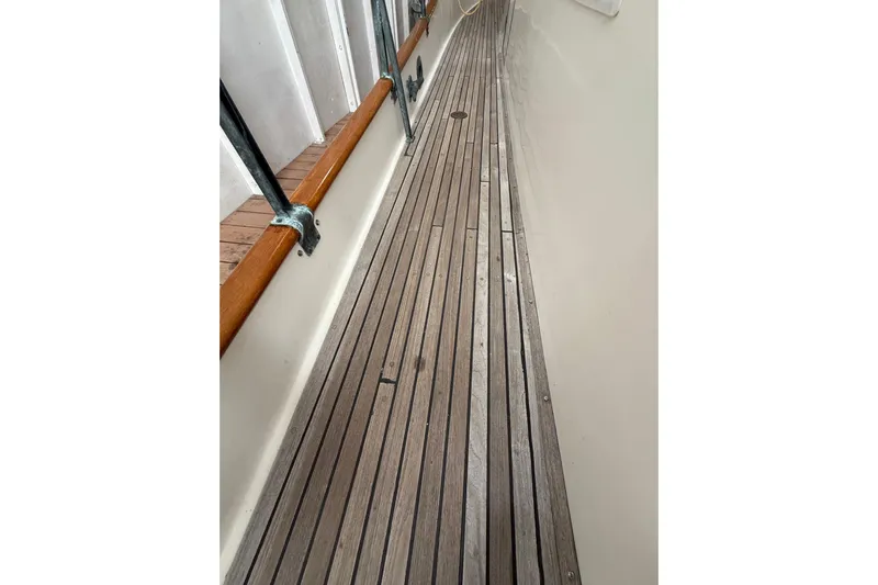  Yacht Photos Pics Teak deck of 1981 Grand Banks 42 Classic yacht, showcasing wooden planks and metal railings.