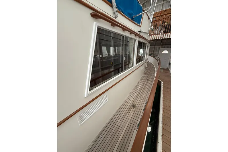  Yacht Photos Pics 1981 Grand Banks 42 Classic yacht, side view with wooden deck and blue canopy.