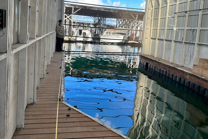  Yacht Photos Pics Indoor marina with a 1981 Grand Banks Classic Tri-cabin yacht docked, reflecting on water.