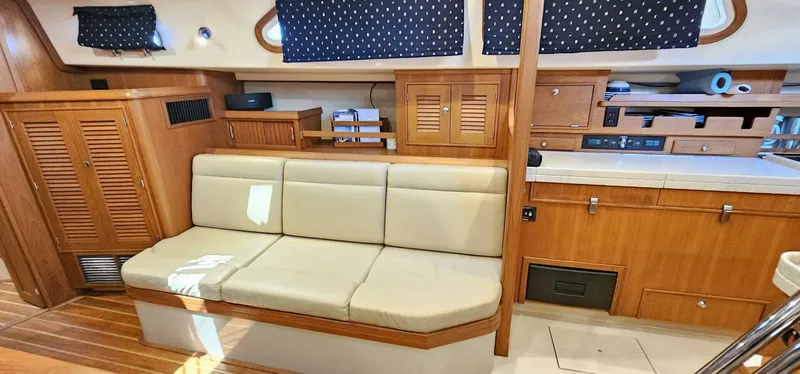  Yacht Photos Pics Interior of 2009 Island Packet 465 yacht with beige seating and wooden cabinetry.