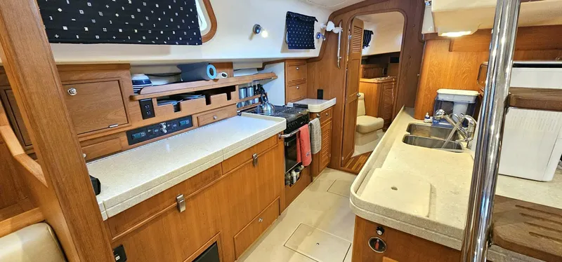  Yacht Photos Pics Interior of 2009 Island Packet 465 yacht, featuring a well-equipped kitchen with wooden cabinetry.
