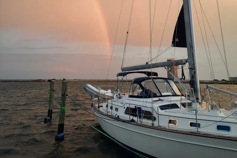  Yacht Photos Pics Island Packet 465 sailboat docked at sunset with a rainbow in the background.