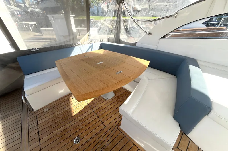  Yacht Photos Pics Luxurious seating area on 2024 Sessa Marine C38 yacht with wooden table and cushioned benches.