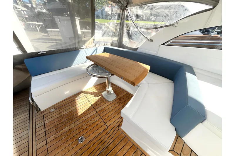  Yacht Photos Pics Luxurious seating area on 2024 Sessa Marine C38 yacht with wooden table and cushioned benches.