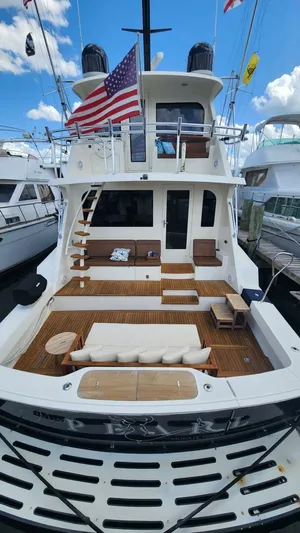 Miss Pearl Yacht Photos Pics 1989 Hatteras 65 Enclosed Bridge yacht with spacious deck and American flag.