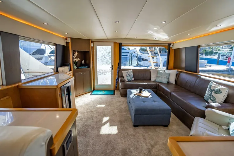 Miss Pearl Yacht Photos Pics Luxurious interior of 1989 Hatteras 65 Enclosed Bridge yacht with plush seating and modern decor.