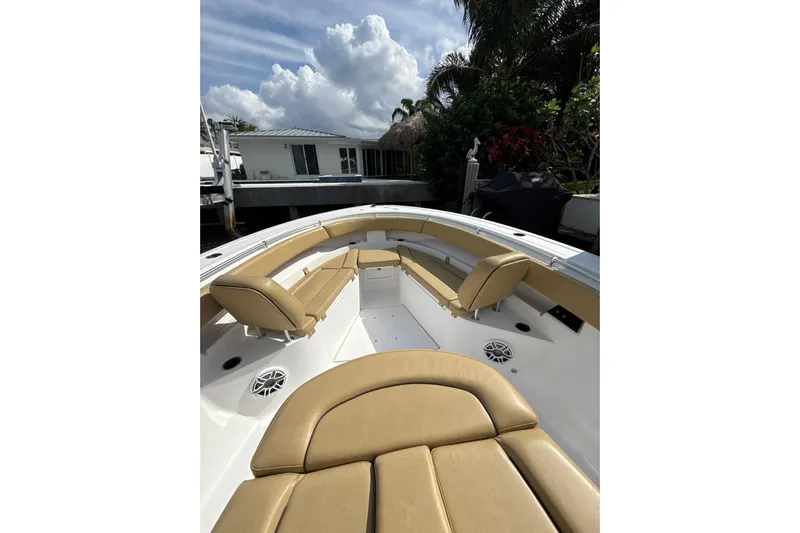 Scungilli Yacht Photos Pics 2023 Sportsman Open 352 Center Console boat with tan seating, docked near a house.
