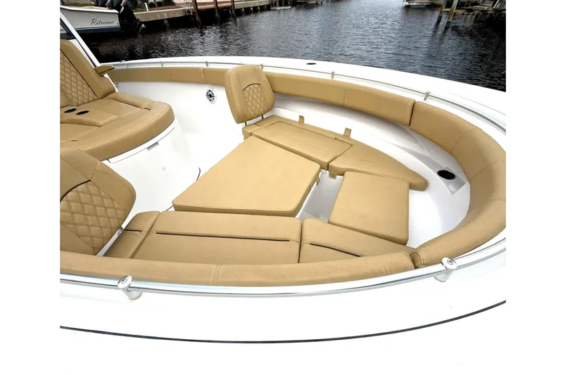 Scungilli Yacht Photos Pics 2023 Sportsman Open 352 Center Console boat with tan cushioned seating, docked by the water.