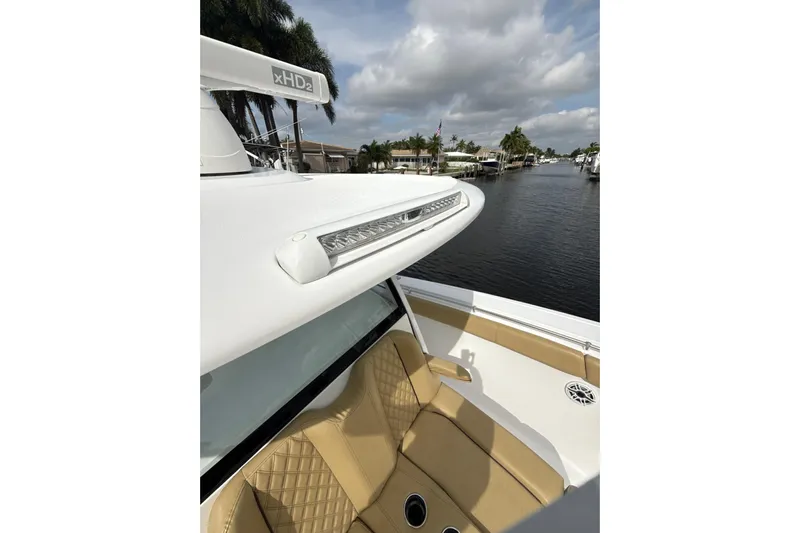 Scungilli Yacht Photos Pics 2023 Sportsman Open 352 Center Console boat with tan seating, docked by a canal.
