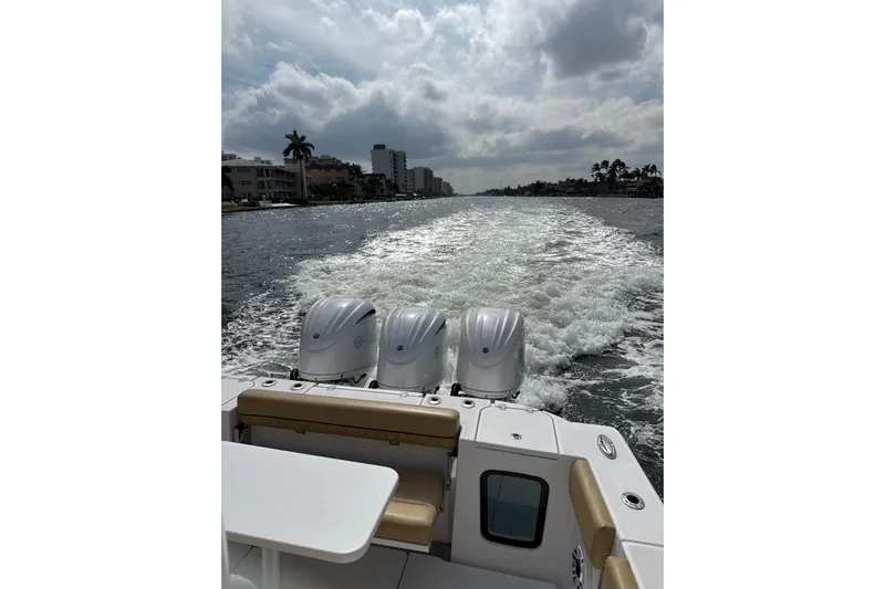Scungilli Yacht Photos Pics 2023 Sportsman Open 352 Center Console cruising on a waterway under cloudy skies.