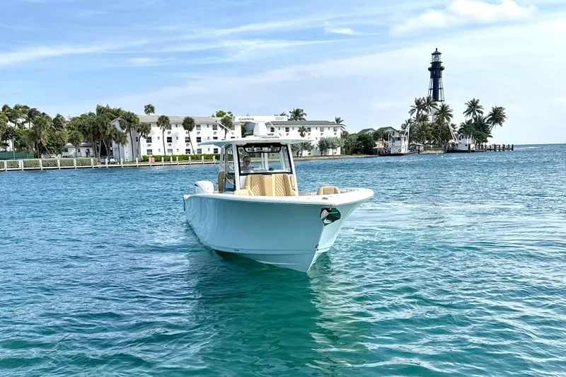 Scungilli Yacht Photos Pics 2023 Sportsman Open 352 Center Console boat on clear blue water near a lighthouse.