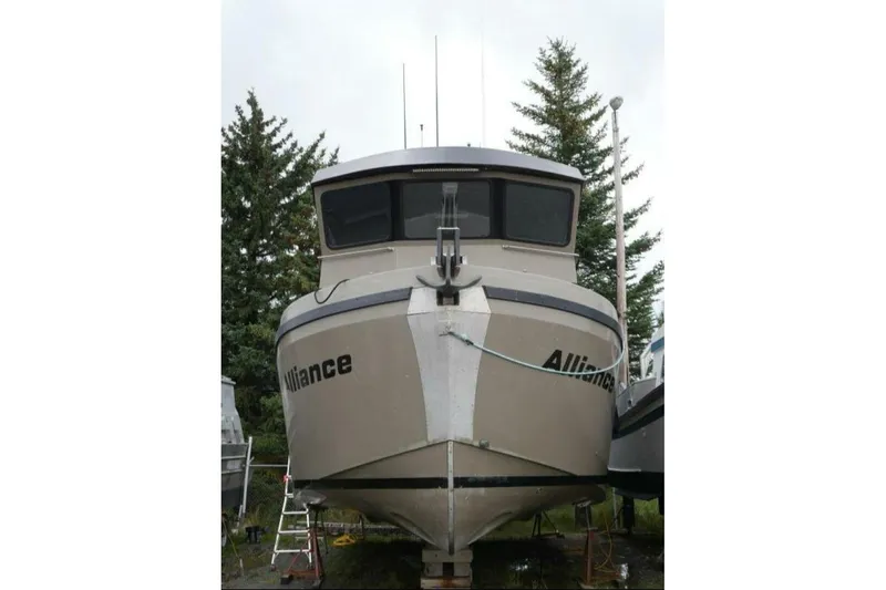 Alliance Yacht Photos Pics 2022 Custom Freestyle Marine 32 boat named "Alliance" on land, surrounded by trees.