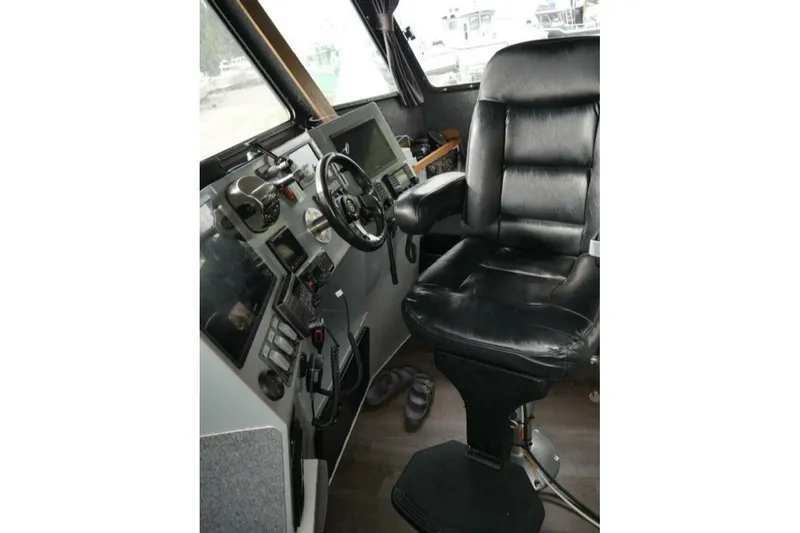 Alliance Yacht Photos Pics Interior of 2022 Custom Freestyle Marine 32 boat with black captain's chair and control panel.
