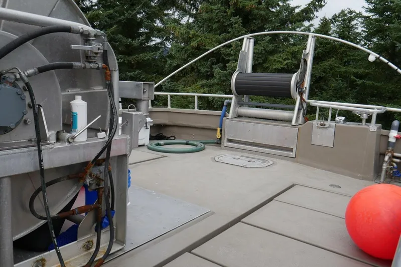 Alliance Yacht Photos Pics Custom Freestyle Marine 32 deck with equipment, hose, and red buoy, surrounded by trees.