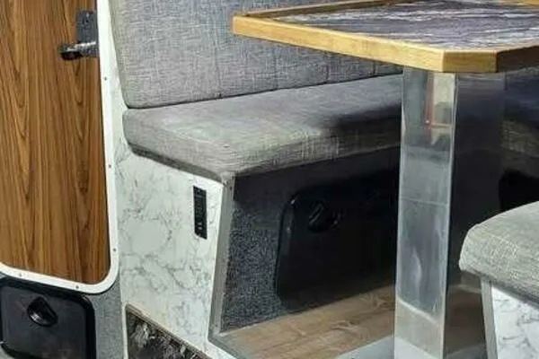 Alliance Yacht Photos Pics Interior of 2022 Custom Freestyle Marine 32, featuring a cozy seating area with a wooden table.