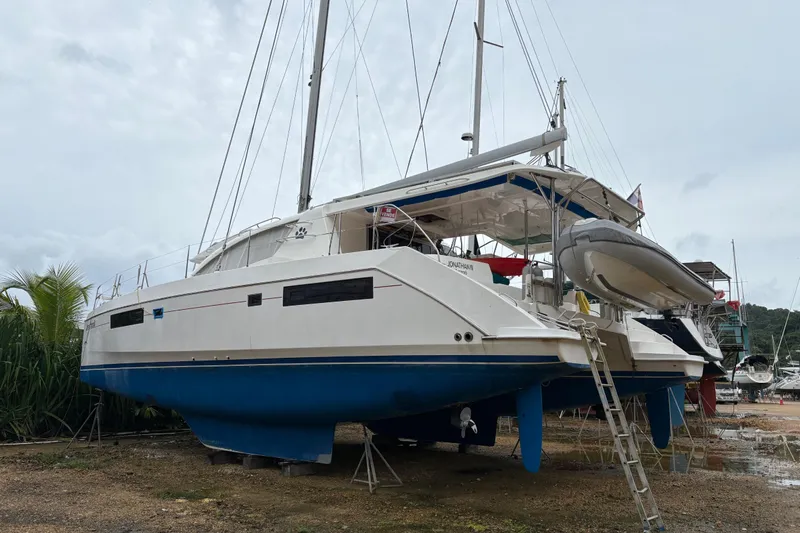 Johnathan III Yacht Photos Pics 2016 Leopard 48 catamaran on land, featuring blue hull and white deck, with dinghy attached.