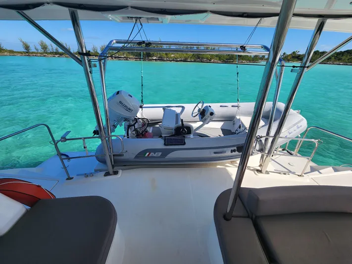 Salty Mitches Yacht Photos Pics 2016 Leopard 51 Powercat with tender on turquoise water, featuring spacious deck and seating.