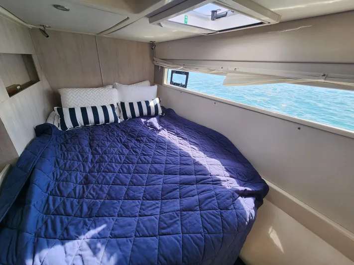 Salty Mitches Yacht Photos Pics Cozy bedroom in 2016 Leopard 51 Powercat with ocean view and blue bedding.