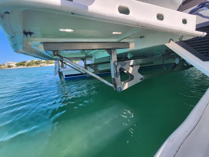 Salty Mitches Yacht Photos Pics 2016 Leopard 51 Powercat, rear view, showing hydraulic lift system over clear water.