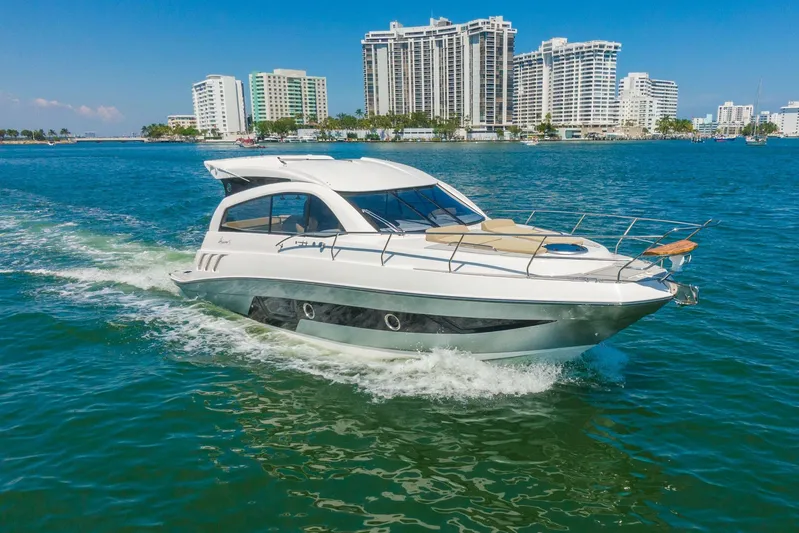  Yacht Photos Pics Luxurious 2026 Hanover 375 yacht cruising in vibrant coastal waters with city skyline backdrop.