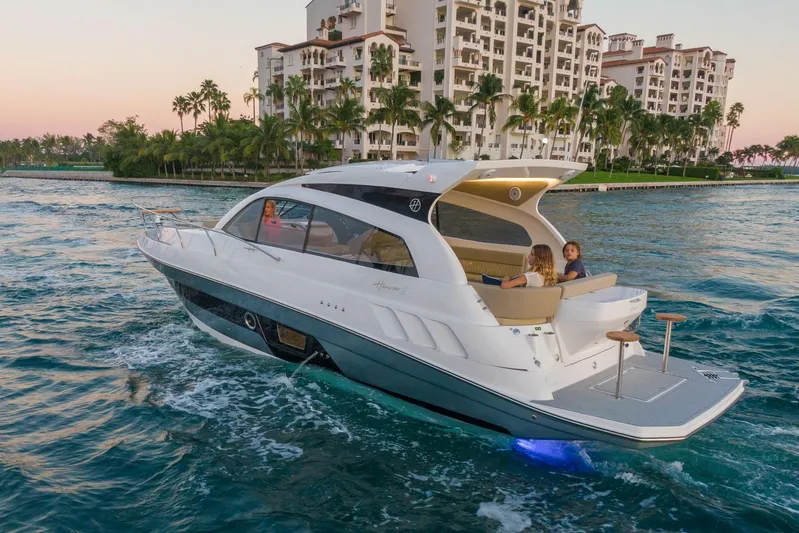  Yacht Photos Pics Luxurious 2026 Hanover 375 yacht cruising near waterfront residences at sunset.