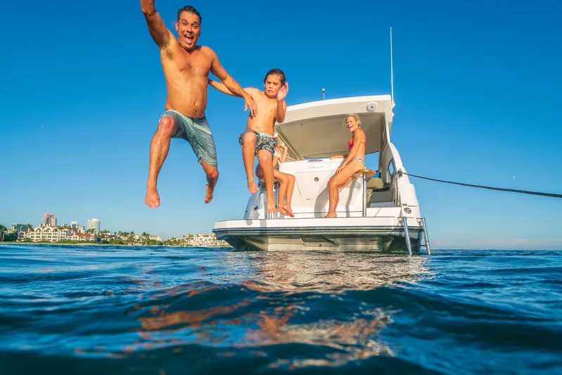  Yacht Photos Pics Family enjoying a sunny day on a 2026 Hanover 375 yacht, jumping into the ocean.