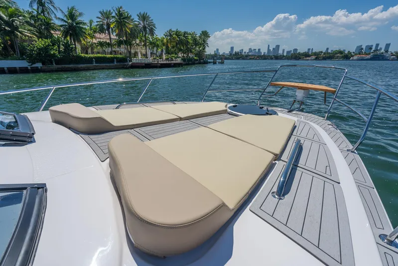  Yacht Photos Pics Luxurious Hanover 375 yacht deck with sun loungers, palm trees, and city skyline in the background.