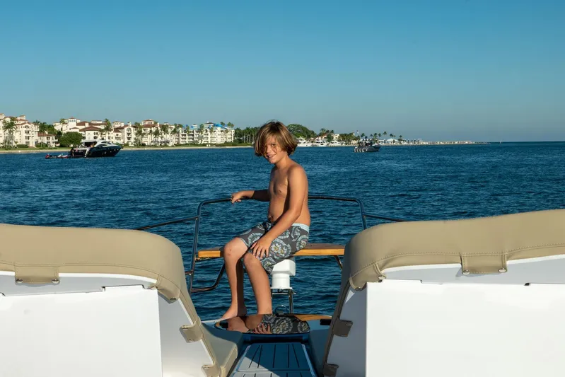  Yacht Photos Pics Boy enjoying a sunny day on a Hanover 375 yacht, 2026 model, near coastal buildings.