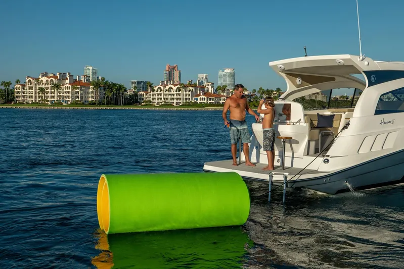  Yacht Photos Pics Family enjoying leisure time on a 2026 Hanover 375 yacht near waterfront buildings.