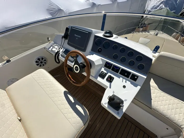 Maurizio Nesti Yacht Photos Pics 2007 Sealine F42/5 yacht helm with wooden steering wheel and modern navigation controls.