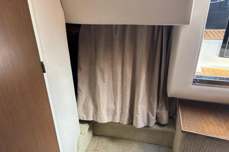 The Braciole Yacht Photos Pics Interior cabin view of 2017 Sea Ray 310 Sundancer with curtain and wooden accents.