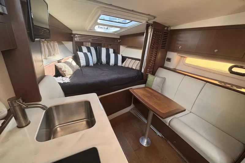 The Braciole Yacht Photos Pics Interior of 2017 Sea Ray 310 Sundancer with cozy seating, bed, and kitchenette.