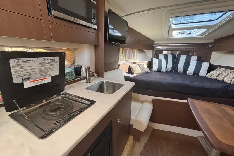 The Braciole Yacht Photos Pics Interior of 2017 Sea Ray 310 Sundancer with kitchenette and cozy sleeping area.