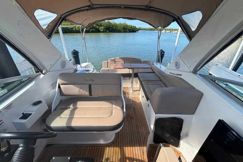 The Braciole Yacht Photos Pics 2017 Sea Ray 310 Sundancer boat interior with seating and table, overlooking serene water.