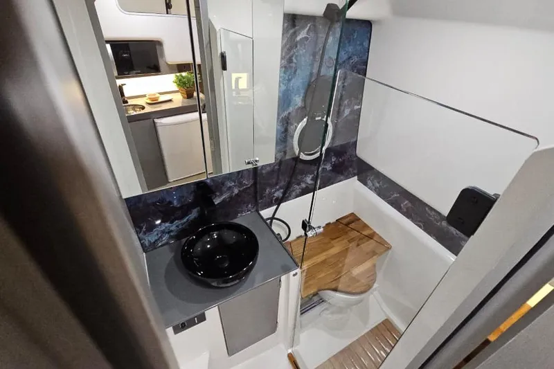  Yacht Photos Pics Modern bathroom in 2026 Hanover 327 RV with sleek black sink and wooden accents.
