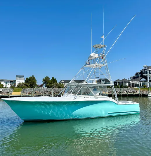 Wire Nut Yacht Photos Pics 2002 Custom Carolina 40 Express Sportfisherman in marina, turquoise hull, clear sky background.