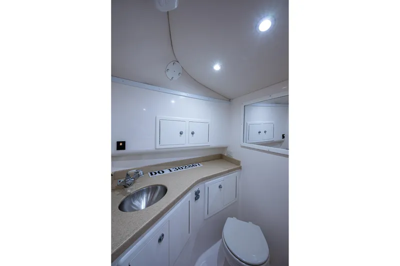 Seaclusion Yacht Photos Pics 2018 Albemarle 290 Express Fisherman bathroom with sink, toilet, and storage cabinets.