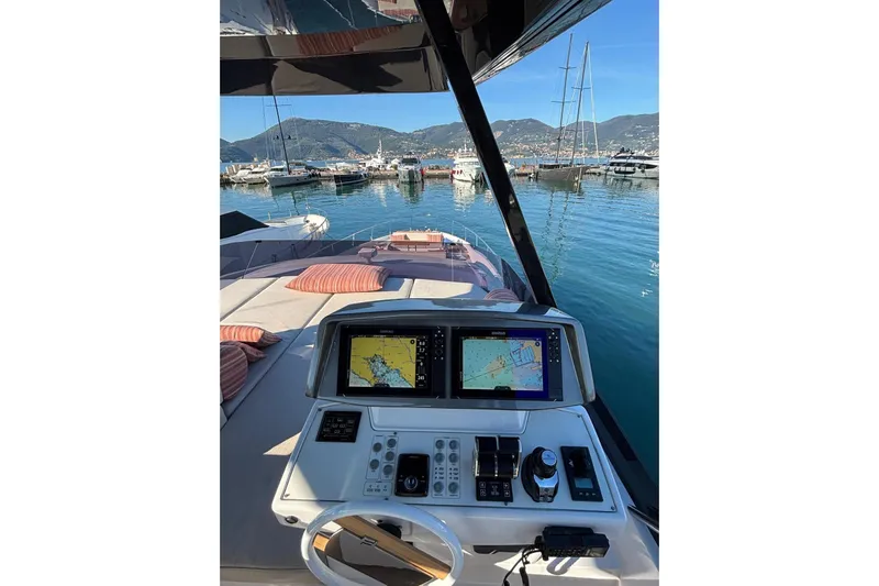  Yacht Photos Pics Cockpit view of 2025 Ferretti Yachts 720, featuring navigation screens and marina backdrop.