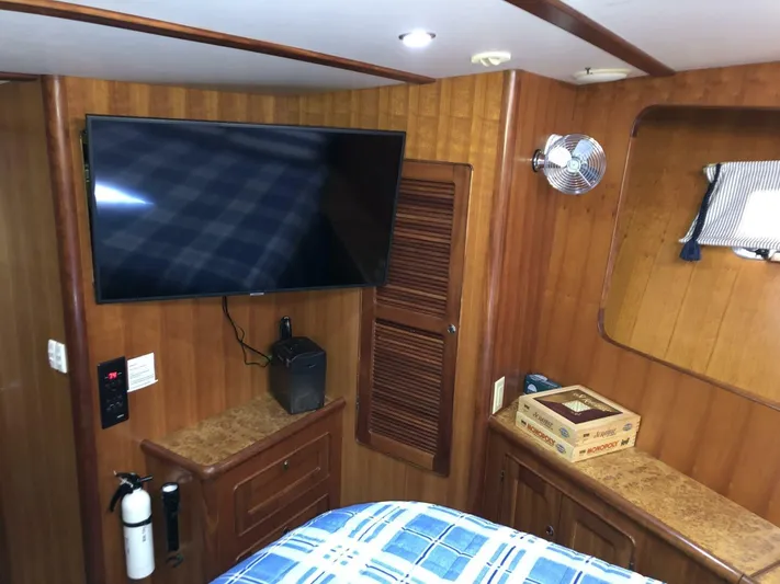 Off The Grid Yacht Photos Pics Interior of 2001 Selene Ocean Trawler with TV, wood paneling, and cozy bedding.