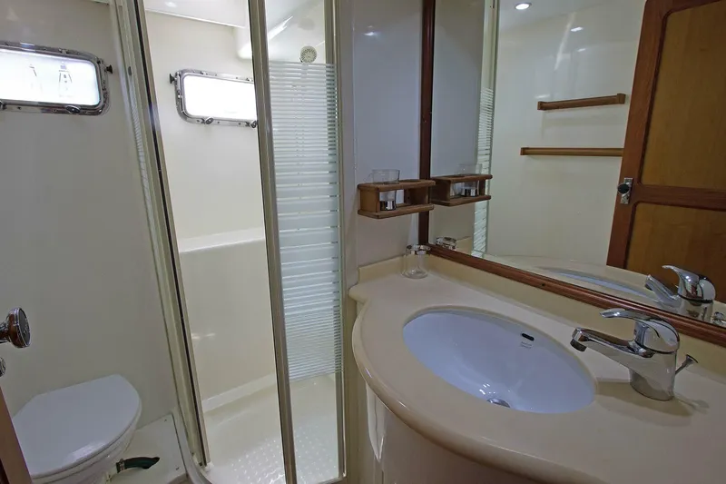 Off The Grid Yacht Photos Pics Bathroom interior of 2001 Selene Ocean Trawler with shower, sink, and wooden accents.