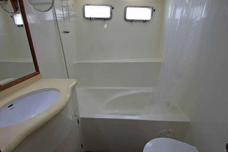 Off The Grid Yacht Photos Pics Bathroom interior of 2001 Selene Ocean Trawler with sink, bathtub, and porthole windows.
