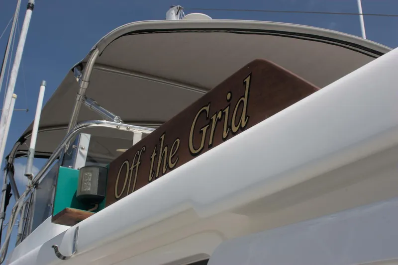 Off The Grid Yacht Photos Pics 2001 Selene Ocean Trawler with "Off the Grid" sign, showcasing sleek design and nautical features.