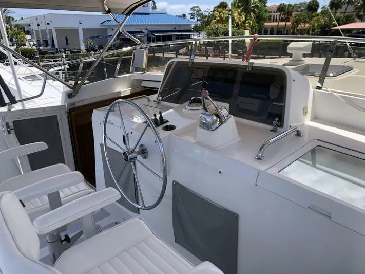 Off The Grid Yacht Photos Pics 2001 Selene Ocean Trawler helm with dual seats and steering wheel, docked in marina.